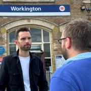 Josh MacAlister talking to staff outside of Workington train station