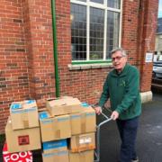 Volunteer Tony Gilks receives the collection for North Lakes Food Bank