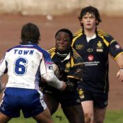 LOCAL DERBY: Haven’s Ade Adebisi runs at Workington Town’s Carl Forber with John Duffy in support