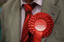 A man wearing a red Labour rosette