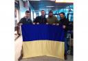 SUPPORT: Kai Wier (far left) in Polish airport holding a Ukrainian flag.