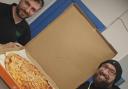 Iain (right) collecting the pizza from a member of staff at Samadi's