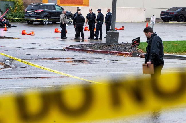 Police collect evidence in a parking lot near Dave and Busters near the Boise Towne Square shopping mall where a shooting occurred