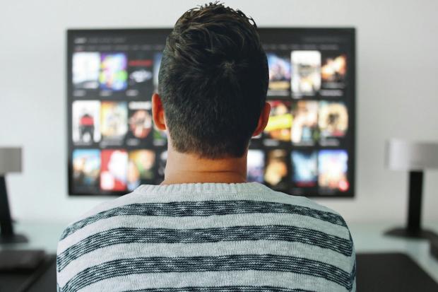 Times and Star: A man watching a smart TV. Credit: Canva
