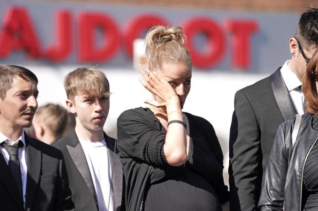 Times and Star: Mourners watch as the coffin of The Wanted star Tom Parker is carried ahead of his funeral. (PA)