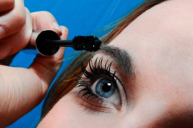 Times and Star: A woman putting on mascara. Credit: Canva