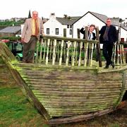 Bill Cameron chairman of maryport partnership, Noel Butters chief executive of MDL and David Martin regeneration manager stand abourd the shipwreck that will be part of the childrens playground being built.pic tom kay    copy thompson